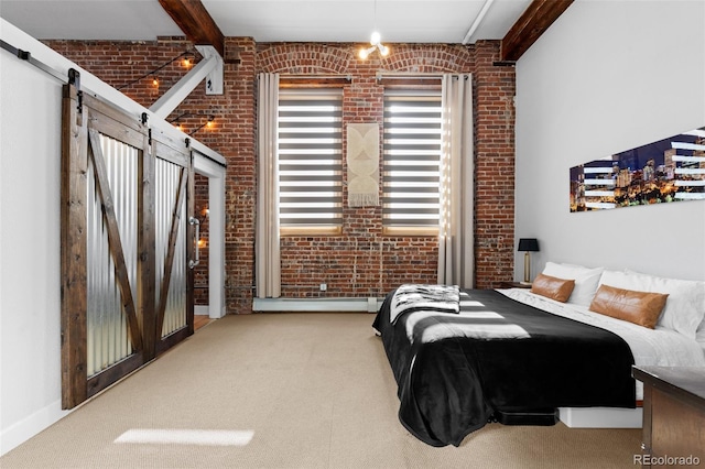 bedroom featuring beam ceiling, a barn door, and brick wall