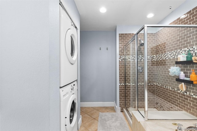 washroom featuring light tile patterned floors and stacked washing maching and dryer