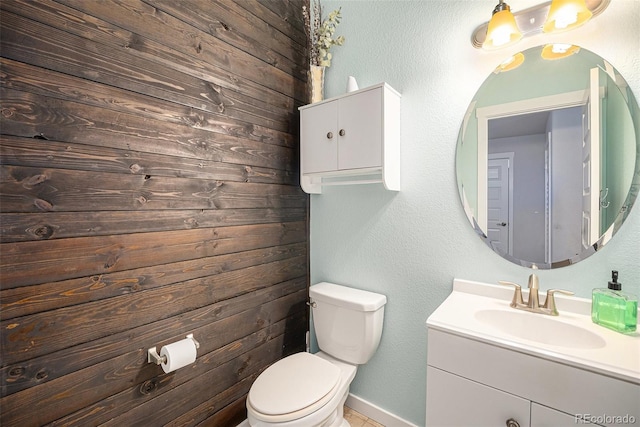 bathroom featuring toilet, vanity, and baseboards