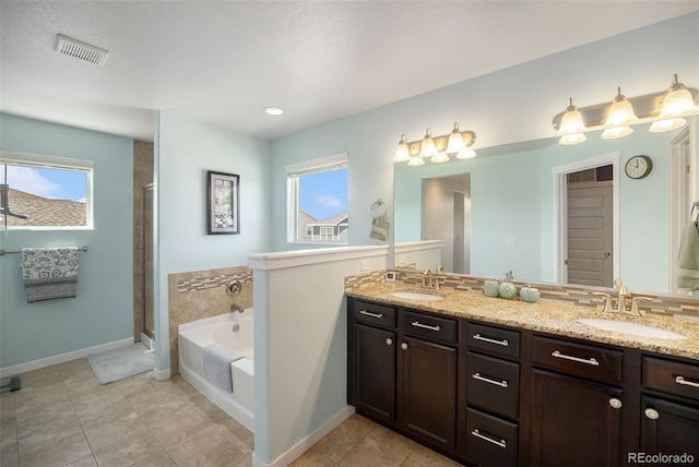 bathroom with double vanity, a garden tub, baseboards, and tile patterned flooring