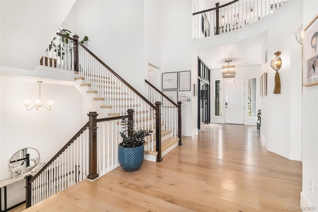 7033 E Lake Cir, Centennial, CO 80111 - entryway featuring a notable chandelier, stairs, a towering ceiling, and hardwood / wood-style flooring