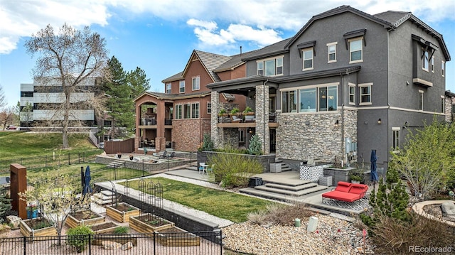 7033 E Lake Cir, Centennial, CO 80111 - back of property with stone siding, stucco siding, fence, a garden, and a balcony