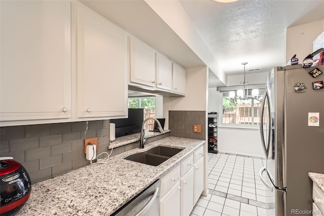 2896 W 119th Ave, Westminster, CO 80234 - kitchen featuring stainless steel appliances, white cabinets, light tile patterned floors, decorative backsplash, and decorative light fixtures