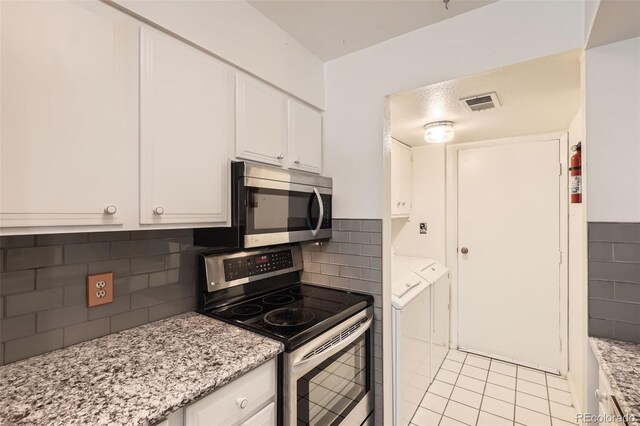 2896 W 119th Ave, Westminster, CO 80234 - kitchen featuring stainless steel appliances, white cabinets, light tile patterned floors, and light stone counters