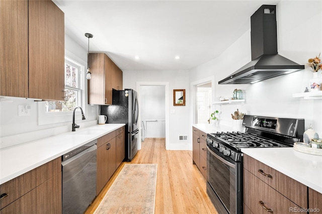 4401 Vrain St, Denver, CO 80212 - kitchen with stainless steel dishwasher, wall chimney exhaust hood, gas range, open shelves, and light wood-type flooring