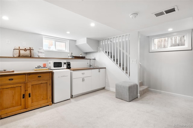 4401 Vrain St, Denver, CO 80212 - kitchen featuring white microwave, light colored carpet, recessed lighting, brown cabinets, and open shelves