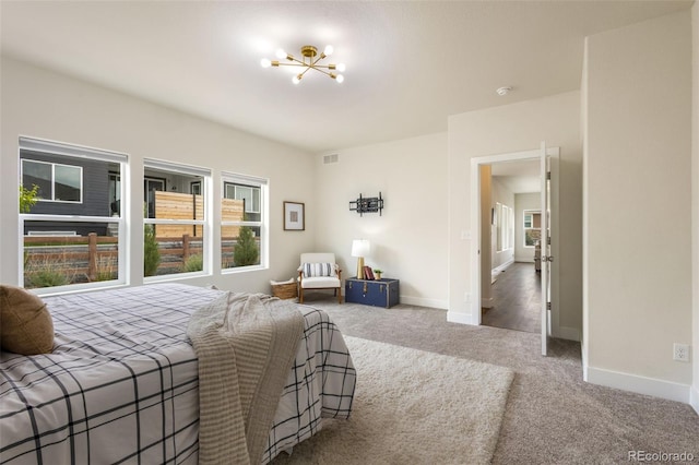 bedroom with carpet, multiple windows, and a notable chandelier