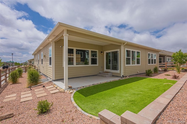 rear view of property featuring a patio area and a yard