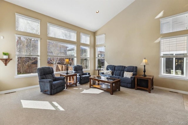 living area featuring baseboards, high vaulted ceiling, and carpet