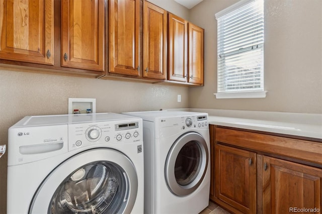 washroom with cabinet space and washer and clothes dryer