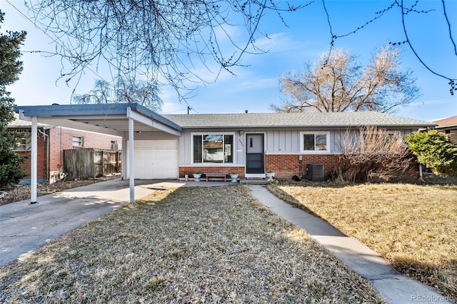 single story home with fence, driveway, an attached garage, brick siding, and board and batten siding