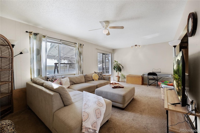 carpeted living area with ceiling fan and a textured ceiling