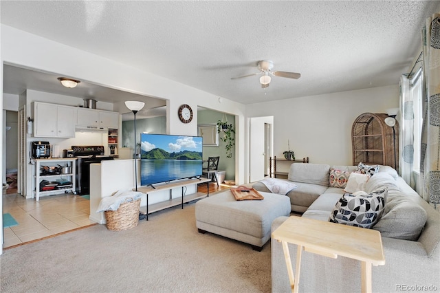 living room featuring light tile patterned floors, light colored carpet, a textured ceiling, and ceiling fan