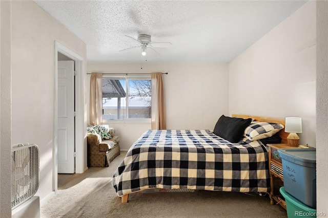 bedroom featuring a ceiling fan, carpet, and a textured ceiling