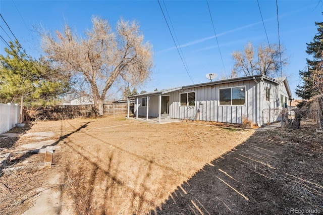 rear view of property with a fenced backyard and board and batten siding