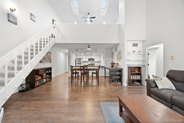 23551 Genesee Village Rd Unit H, Golden, CO 80401 - living room featuring a skylight, stairs, a high ceiling, wood finished floors, and ceiling fan
