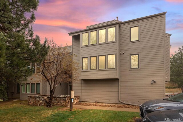 23551 Genesee Village Rd Unit H, Golden, CO 80401 - back of house at dusk with a lawn