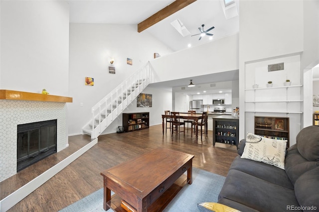 23551 Genesee Village Rd Unit H, Golden, CO 80401 - living area with a tile fireplace, stairs, wood finished floors, a ceiling fan, and beam ceiling