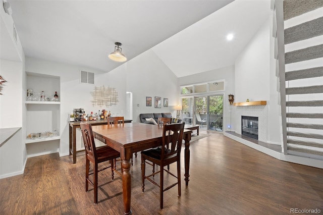 23551 Genesee Village Rd Unit H, Golden, CO 80401 - dining space with high vaulted ceiling, wood finished floors, a glass covered fireplace, and baseboards