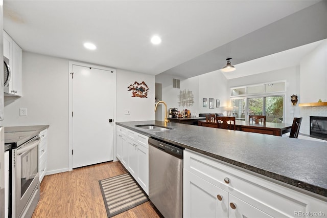 23551 Genesee Village Rd Unit H, Golden, CO 80401 - kitchen featuring stainless steel appliances, a sink, light wood-type flooring, white cabinets, and recessed lighting