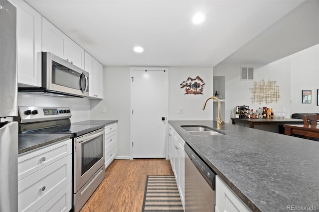 23551 Genesee Village Rd Unit H, Golden, CO 80401 - kitchen with stainless steel appliances, a sink, white cabinets, light wood-style flooring, and recessed lighting