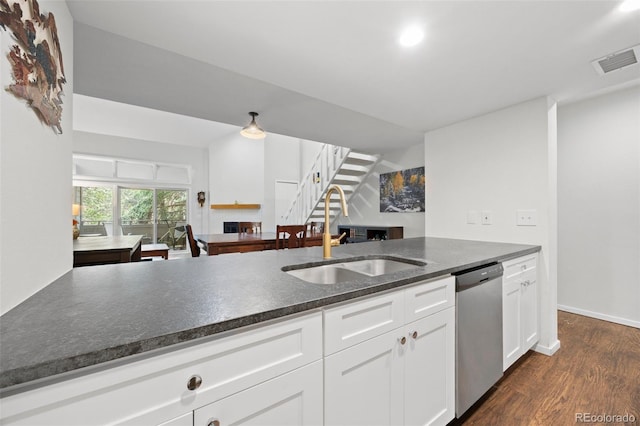 23551 Genesee Village Rd Unit H, Golden, CO 80401 - kitchen with a sink, stainless steel dishwasher, dark wood-style floors, white cabinets, and a fireplace