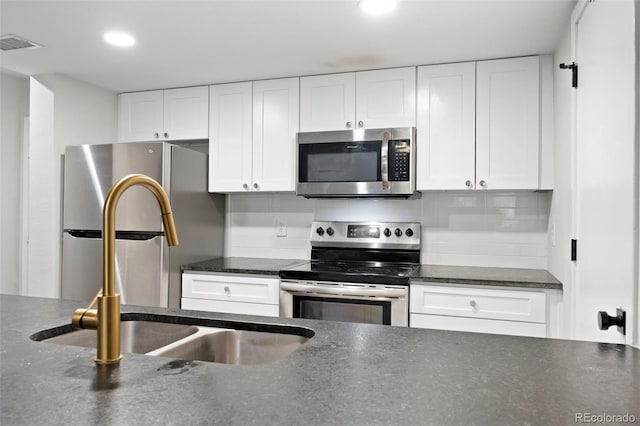 23551 Genesee Village Rd Unit H, Golden, CO 80401 - kitchen featuring stainless steel appliances, white cabinets, a sink, recessed lighting, and tasteful backsplash