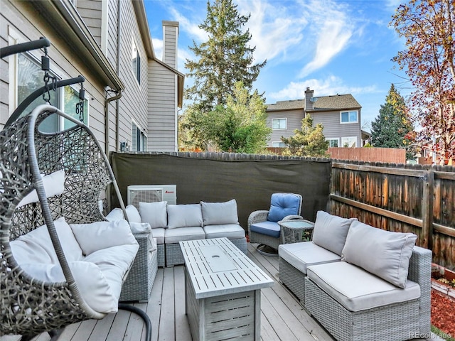 wooden deck featuring outdoor lounge area and a fenced backyard