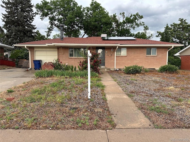 1761 W 82nd Pl, Denver, CO 80221 - ranch-style house with an attached garage, brick siding, solar panels, and concrete driveway