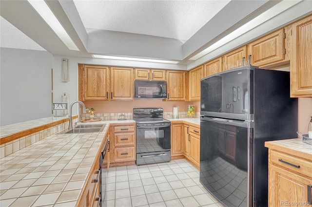 kitchen with black appliances, sink, light tile patterned flooring, a textured ceiling, and tile counters