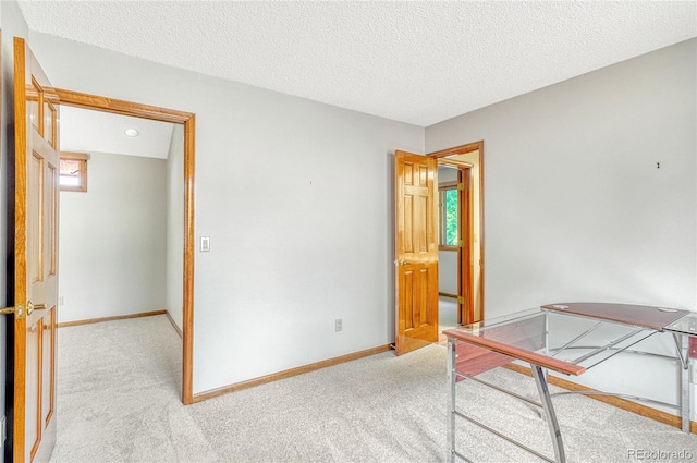 unfurnished bedroom with light colored carpet and a textured ceiling