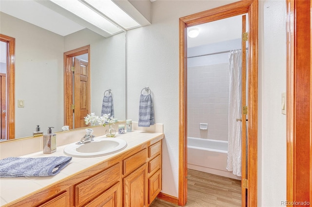 bathroom with shower / bathtub combination with curtain, vanity, and hardwood / wood-style floors