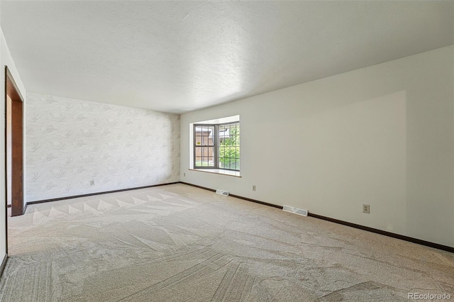 1354 S Macon St, Aurora, CO 80012 - carpeted spare room featuring baseboards, wallpapered walls, and a textured ceiling