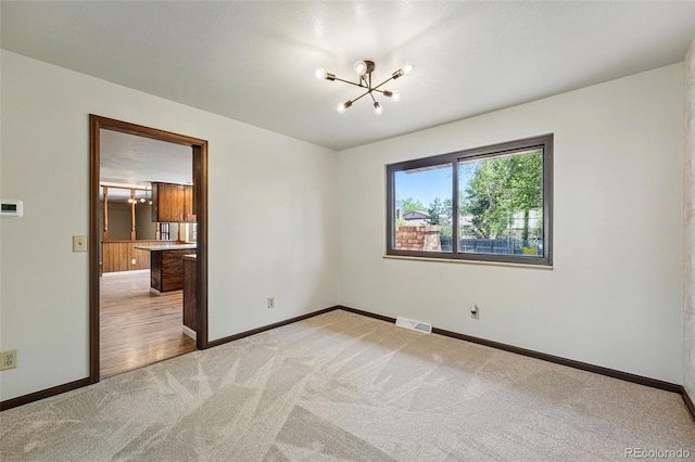 1354 S Macon St, Aurora, CO 80012 - spare room with light carpet, a chandelier, and baseboards