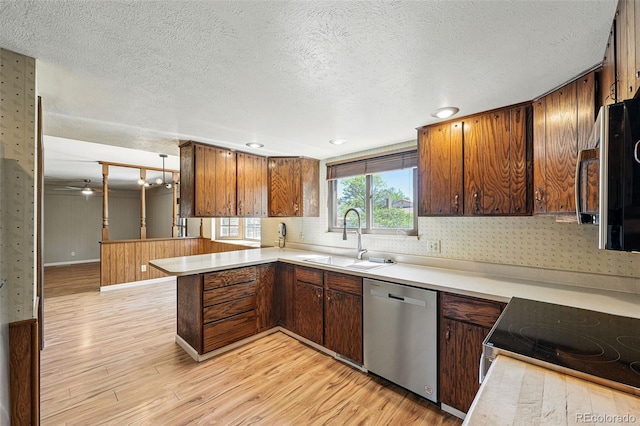 1354 S Macon St, Aurora, CO 80012 - kitchen featuring stainless steel appliances, a sink, light wood-type flooring, a peninsula, and light countertops