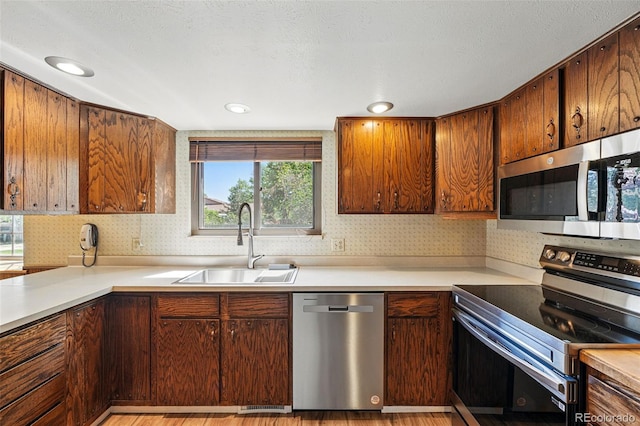 1354 S Macon St, Aurora, CO 80012 - kitchen featuring stainless steel appliances, a sink, light countertops, and light wood-style flooring