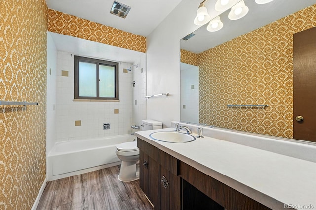 1354 S Macon St, Aurora, CO 80012 - full bath with wallpapered walls, toilet, wood finished floors, vanity, and tub / shower combination