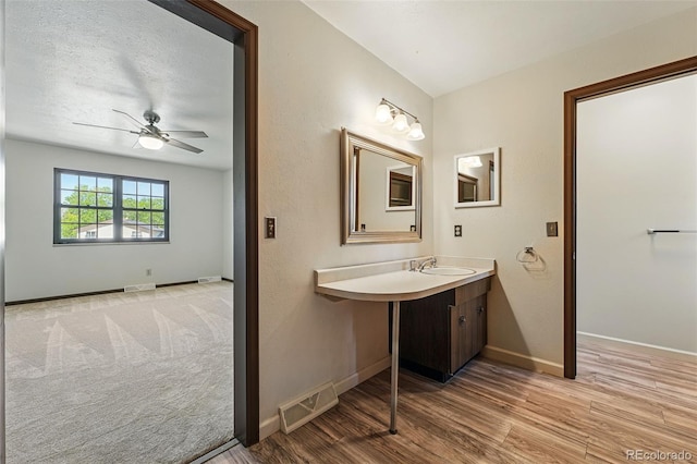 1354 S Macon St, Aurora, CO 80012 - bathroom featuring ceiling fan, wood finished floors, baseboards, and vanity