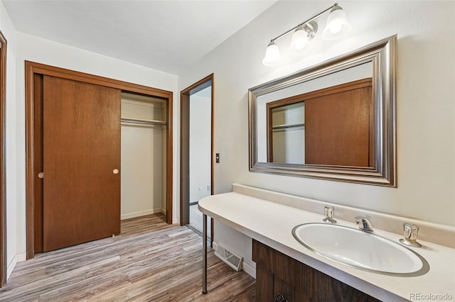 1354 S Macon St, Aurora, CO 80012 - bathroom with wood finished floors, vanity, and baseboards