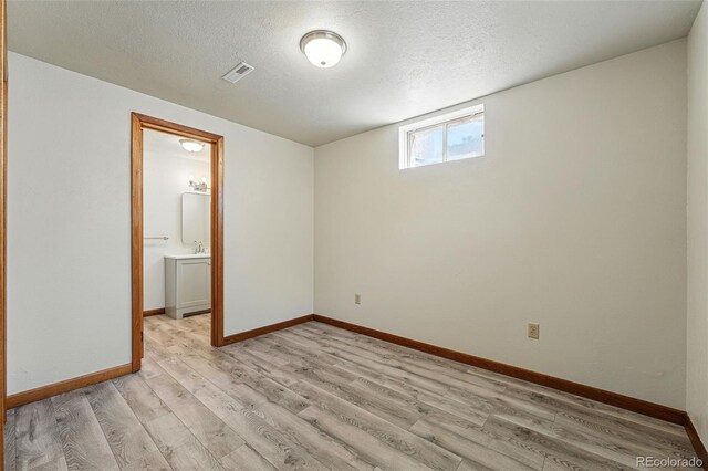 1354 S Macon St, Aurora, CO 80012 - empty room featuring light wood-style floors, a textured ceiling, and baseboards