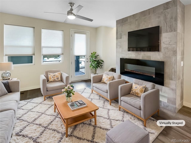 living room with ceiling fan, a fireplace, and light hardwood / wood-style flooring