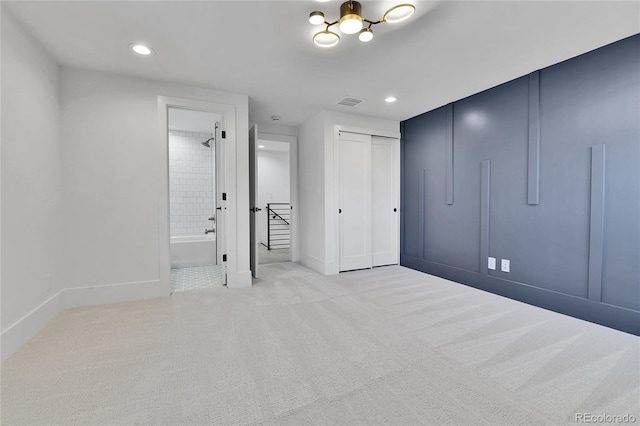unfurnished bedroom featuring carpet floors, baseboards, a closet, recessed lighting, and ensuite bathroom
