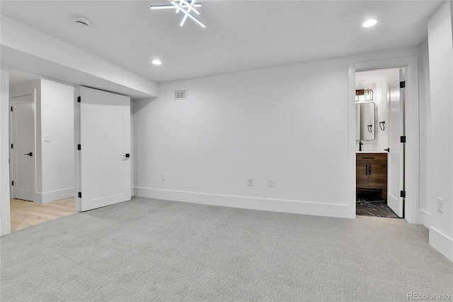 finished basement featuring light colored carpet, recessed lighting, and baseboards