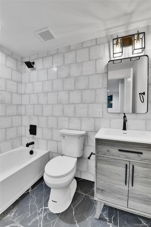 full bathroom featuring marble finish floors, toilet, vanity, and bathtub / shower combination