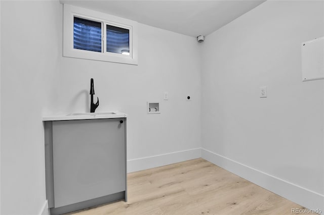 washroom with electric dryer hookup, hookup for a washing machine, light wood finished floors, and baseboards