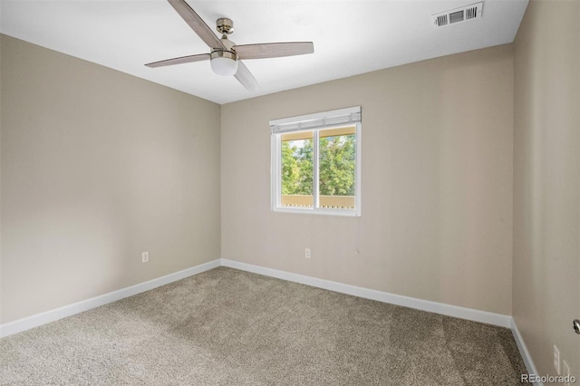 carpeted spare room featuring ceiling fan