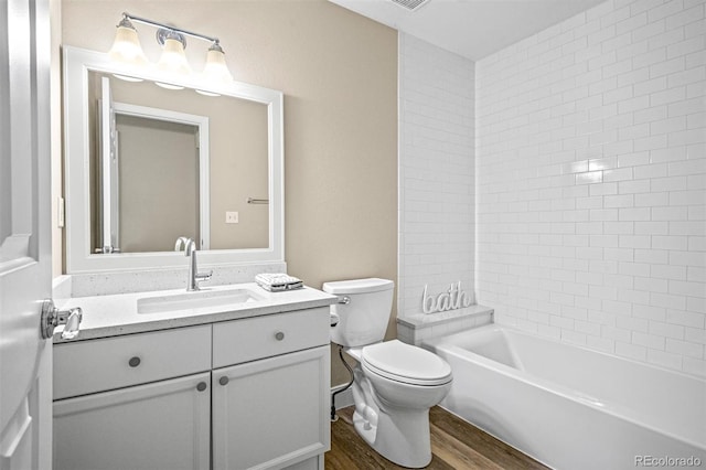 full bathroom with hardwood / wood-style flooring, vanity, toilet, and tiled shower / bath combo