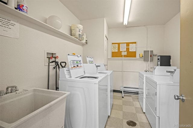 clothes washing area with washing machine and dryer, sink, a baseboard heating unit, and electric panel