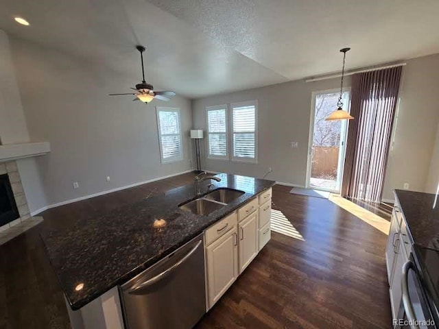 kitchen featuring a tile fireplace, open floor plan, a sink, and stainless steel dishwasher