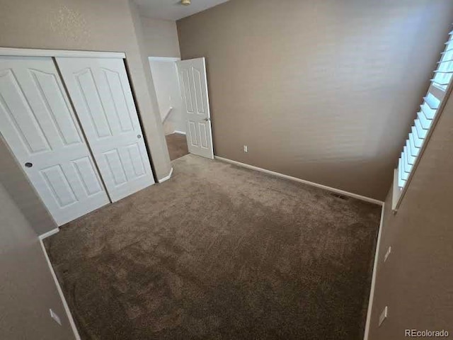 unfurnished bedroom featuring a closet, carpet flooring, and baseboards